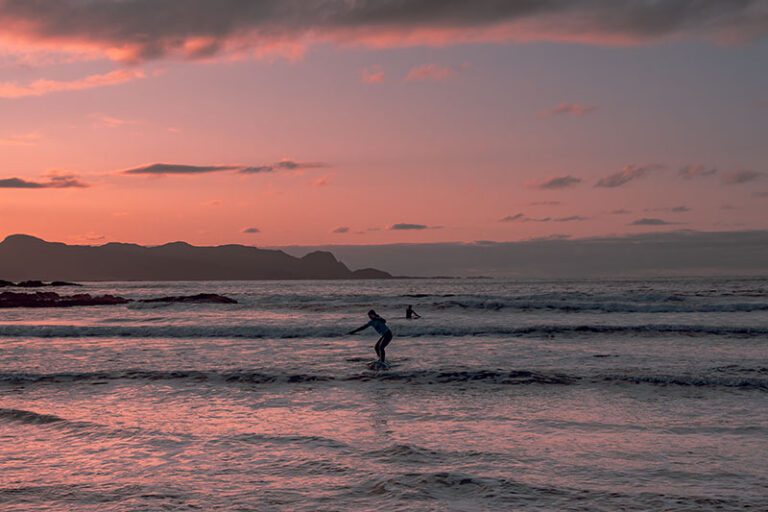 Bilde av surfere i solnedgang