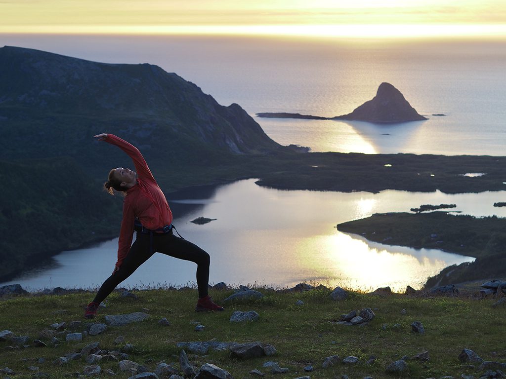 Bilde av dame som gjør yoga på fjellet